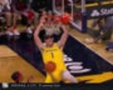 Michigan’s Hunter Dickinson throws down a two-hand slam to increase the lead